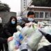 Para sukarelawan memasukkan sayuran, yang diperuntukkan bagi warga yang sedang menjalani karantina di rumah, ke sebuah truk di Kota Yuzhou, Provinsi Henan, China tengah, pada 10 Januari 2022. (Xinhua/Li Jianan)