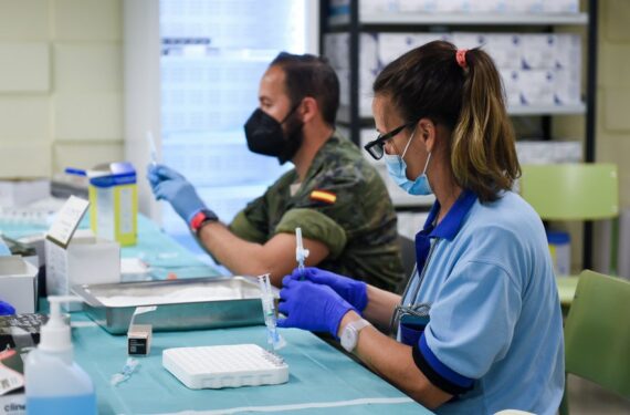 Staf rumah sakit dan personel militer bekerja di tempat vaksinasi di Universitas Seville di Seville, Spanyol, pada 7 Januari 2022. (Xinhua/Gustavo Valiente)