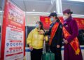 Polisi wanita khusus kereta api dan kru kereta menjelaskan tips perjalanan yang aman kepada seorang penumpang di Kota Chongqing, China barat daya, pada 17 Januari 2022. (Xinhua/Tang Yi)
