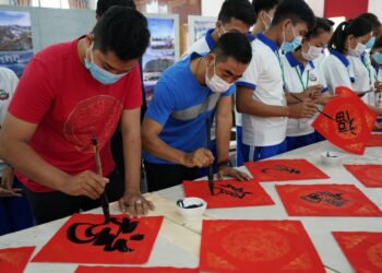 Para peserta menulis kaligrafi untuk mendukung Olimpiade Musim Dingin Beijing 2022 di sebuah acara di Phnom Penh, Kamboja, pada 10 Januari 2022. (Xinhua/Bunseng)