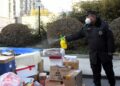 Seorang petugas mendisinfeksi paket yang akan dikirim ke warga di sebuah area permukiman di Distrik Haidian, Beijing, ibu kota China, pada 16 Januari 2022. (Xinhua/Ren Chao)