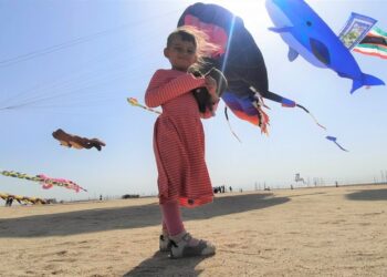 Seorang anak menyaksikan layang-layang saat hari libur nasional di Kegubernuran Ahmadi, Kuwait, pada 2 Maret 2022. (Xinhua/Asad)