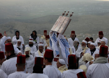 NABLUS, Seorang pendeta dari komunitas Yahudi Samaria mengangkat gulungan Taurat saat ziarah untuk hari raya Paskah Yahudi di puncak Gunung Gerizim, dekat Kota Nablus, Tepi Barat, pada 21 April 2022. (Xinhua/Ayman Nobani)