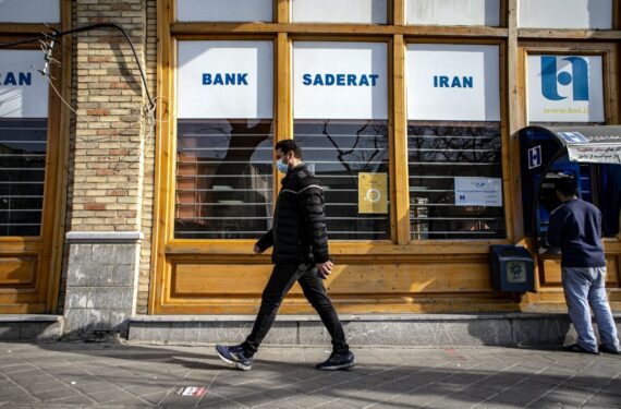 Seorang pria berjalan melewati sebuah bank Iran di Teheran, Iran, pada 28 Januari 2021. (Xinhua/Ahmad Halabisaz)