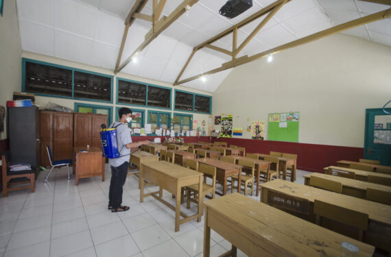 BANDUNG, Seorang pria menyemprotkan disinfektan di ruang kelas sebagai upaya pencegahan melalui penerapan Perilaku Hidup Bersih dan Sehat (PHBS) selama hari pertama masuk sekolah usai liburan Idul Fitri di Bandung, Provinsi Jawa Barat, pada 12 Mei 2022. (Xinhua/Septianjar)