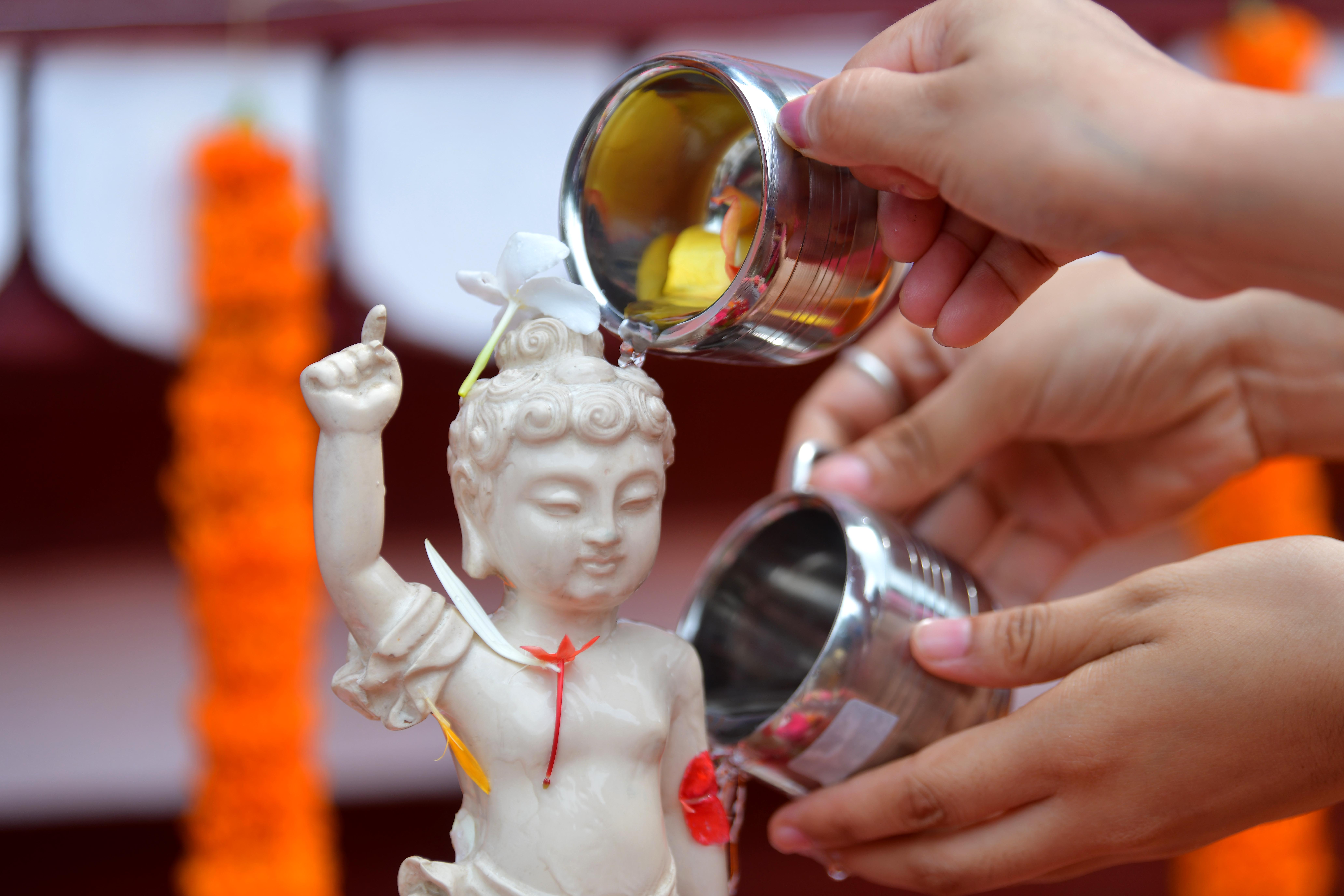 AGARTALA, Sejumlah umat Buddha menuangkan air pada patung Buddha dalam perayaan Hari Raya Waisak di Wihara Benuban Vihar di Agartala, ibu kota Negara Bagian Tripura, India timur laut, pada 16 Mei 2022. (Xinhua/Str)