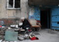 MARIUPOL, Seorang warga setempat memasak di luar sebuah bangunan yang rusak di kota pelabuhan Mariupol pada 15 Mei 2022. (Xinhua/Victor)