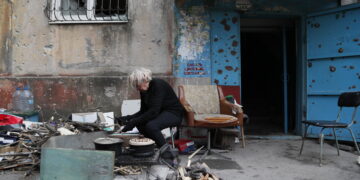 MARIUPOL, Seorang warga setempat memasak di luar sebuah bangunan yang rusak di kota pelabuhan Mariupol pada 15 Mei 2022. (Xinhua/Victor)