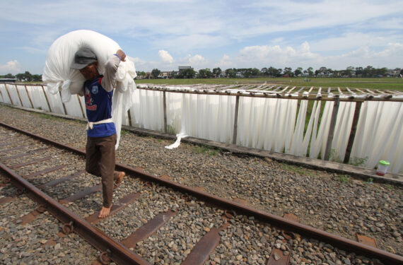 SUKOHARJO, Seorang pekerja membawa kain shantung sebelum proses pewarnaan di Mojolaban di Kabupaten Sukoharjo, Provinsi Jawa Tengah, pada 17 Mei 2022. (Xinhua/Bram Selo)