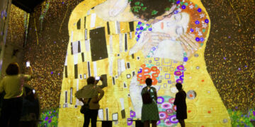 AMSTERDAM, Para pengunjung mengamati sebuah karya seni digital yang dipajang dalam sebuah pameran di Fabrique des Lumieres di Amsterdam, Belanda, pada 18 Mei 2022. Menggunakan teknologi mutakhir dengan proyeksi cahaya dan musik, Fabrique des Lumieres menyuguhkan pameran yang imersif dari sejumlah seniman klasik, modern, dan kontemporer. Program pameran perdana di tempat tersebut mencakup pameran yang menampilkan sejumlah karya seni digital dari seniman terkenal Gustav Klimt dan Friedensreich Hundertwasser serta kreasi kontemporer "Journey" dan "Memories". (Xinhua/Sylvia Lederer)