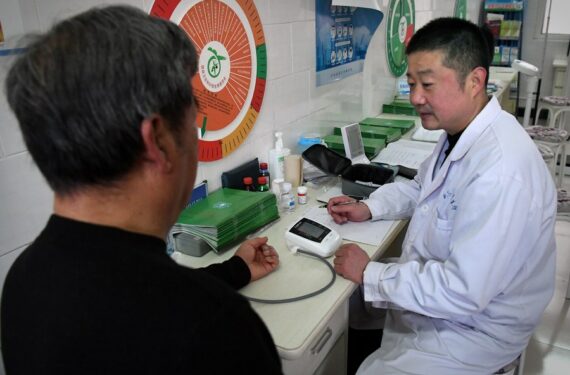 Dokter desa Chen Shaojie mengukur tekanan darah seorang penduduk desa di klinik desa di Desa Chenjiagou, wilayah Wenxian, Provinsi Henan, China tengah, pada 14 Desember 2020. (Xinhua/Li Jianan)