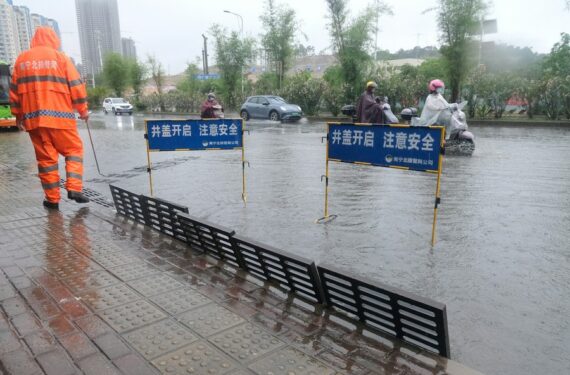 Foto yang diabadikan pada 12 Mei 2022 ini menunjukkan seorang petugas mengeringkan genangan air di Jalan Qinghuan di Nanning, ibu kota Daerah Otonom Etnis Zhuang Guangxi, China selatan. (Xinhua/Zhou Hua)