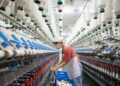 Seorang staf bekerja di lini produksi sebuah perusahaan tekstil di Nanmo yang terletak di Kota Hai'an, Provinsi Jiangsu, China timur, pada 28 Februari 2022. (Xinhua/Zhai Huiyong)