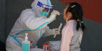 Tenaga kesehatan mengambil sampel usap (swab) dari seorang anak untuk tes asam nukleat di sebuah kawasan permukiman di Distrik Haidian, Beijing, ibu kota China, pada 13 Mei 2022. (Xinhua/Ren Chao)