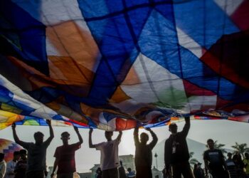 Sejumlah orang bersiap melepaskan balon udara dalam festival balon udara yang digelar pada liburan Idul Fitri di Stadion Ronggolawe, Kabupaten Wonosobo, Provinsi Jawa Tengah, pada 6 Mei 2022. (Xinhua/Agung Supriyanto)