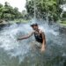JAMMU, Seorang anak laki-laki melompat ke dalam tangki air untuk mendinginkan tubuh dari cuaca panas pada hari yang terik di tengah musim panas di Jammu, ibu kota musim dingin Kashmir yang dikuasai India, pada 15 Juni 2022. (Xinhua/Str)