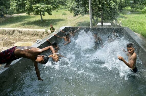 JAMMU, Anak-anak bermain air di tangki air untuk mendinginkan tubuh dari cuaca panas pada hari yang terik di tengah musim panas di Jammu, ibu kota musim dingin Kashmir yang dikuasai India, pada 15 Juni 2022. (Xinhua/Str)