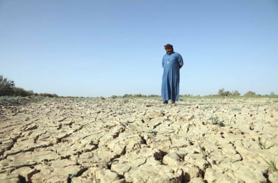 SALAHUDIN, Seorang petani berdiri di lahan pertanian miliknya yang terlihat retak akibat kekeringan dan kelangkaan air di Provinsi Salahudin, Irak, pada 14 Juni 2022. (Xinhua/Khalil Dawood)