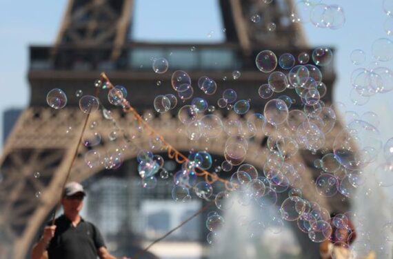 PARIS, Seorang seniman jalanan membuat gelembung sabun di dekat Menara Eiffel di Paris, Prancis, pada 16 Juni 2022. (Xinhua/Gao Jing)