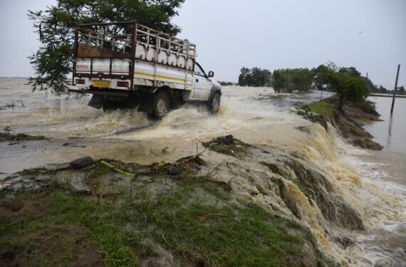 NAGAON, Sebuah kendaraan melintasi jalan yang tergenang banjir di Distrik Nagaon, Negara Bagian Assam, India timur laut, pada 17 Juni 2022. (Xinhua/Str)