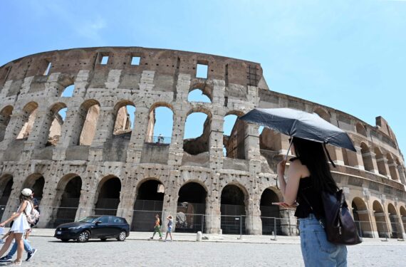ROMA, Seorang wanita berlindung dari sengatan matahari menggunakan payung saat cuaca panas di Colosseum di Roma, Italia, pada 17 Juni 2022. (Xinhua/Alberto Lingria)