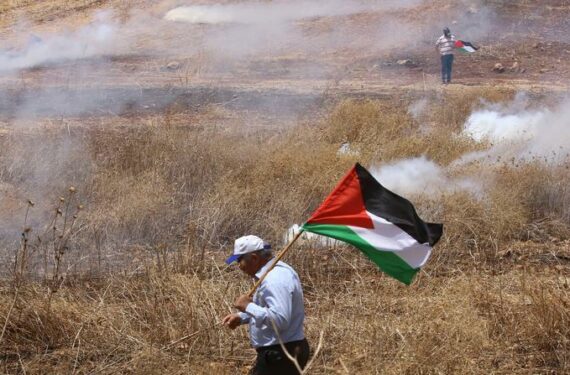 NABLUS, Para pengunjuk rasa Palestina memegang bendera dalam bentrokan menyusul aksi unjuk rasa terhadap perluasan permukiman Yahudi di Desa Beit Dajan, sebelah timur Kota Nablus, Tepi Barat, pada 17 Juni 2022. (Xinhua/Nidal Eshtayeh)