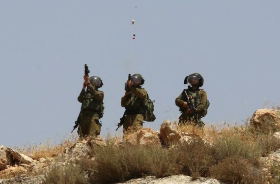 NABLUS, Seorang tentara Israel menembakkan sebuah tabung gas air mata ke arah para pengunjuk rasa Palestina dalam bentrokan menyusul aksi unjuk rasa terhadap perluasan permukiman Yahudi di Desa Beit Dajan, sebelah timur Kota Nablus, Tepi Barat, pada 17 Juni 2022. (Xinhua/Nidal Eshtayeh)