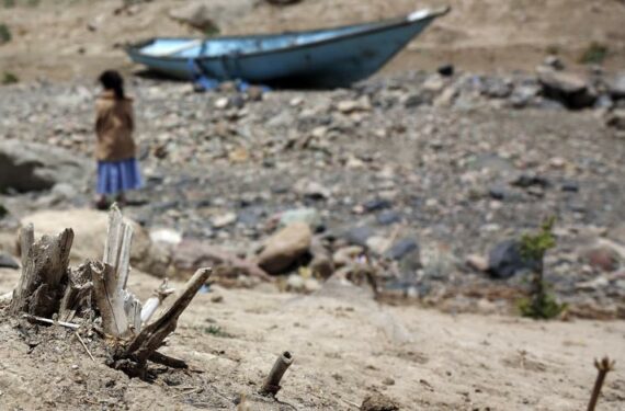 SANAA, Seorang anak perempuan berdiri di depan sebuah perahu yang ditinggalkan terdampar di danau yang mengering di pinggiran Sanaa, ibu kota Yaman, pada 17 Juni 2022. (Xinhua/Mohammed Mohammed)