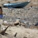 SANAA, Seorang anak perempuan berdiri di depan sebuah perahu yang ditinggalkan terdampar di danau yang mengering di pinggiran Sanaa, ibu kota Yaman, pada 17 Juni 2022. (Xinhua/Mohammed Mohammed)