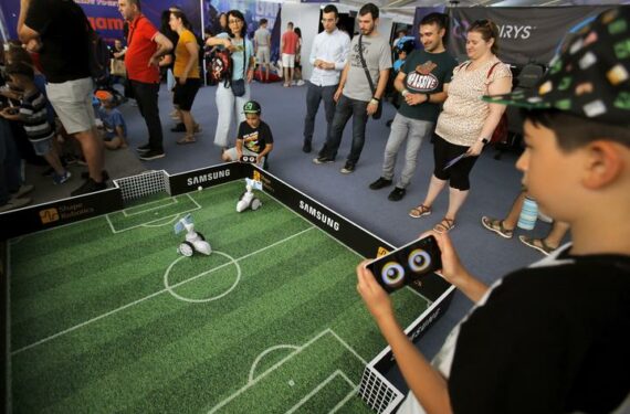 BUCHAREST, Anak-anak bermain sepak bola dengan pemain robot dalam ajang Bucharest Tech Week di Bucharest, Rumania, pada 19 Juni 2022. Bucharest Tech Week adalah acara teknologi tahunan yang bertujuan untuk menyatukan tren-tren baru di bidang teknologi dari seluruh dunia dan penerapan penemuan ilmiah baru dalam kehidupan sehari-hari. (Xinhua/Cristian Cristel)