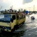 SEMARANG, Orang-orang naik truk bak terbuka mengarungi genangan banjir yang dipicu oleh tingginya air pasang laut di Pelabuhan Tanjung Emas di pesisir Semarang, Provinsi Jawa Tengah, pada 20 Juni 2022. (Xinhua/Rahman Indra)
