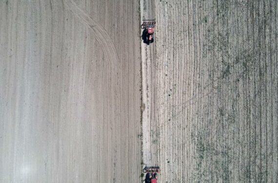 ANKARA, Foto dari udara yang diabadikan pada 20 Juni 2022 ini menunjukkan sejumlah petani mengemudikan traktor di sebuah ladang di Ankara, Turki. (Xinhua/Mustafa Kaya)