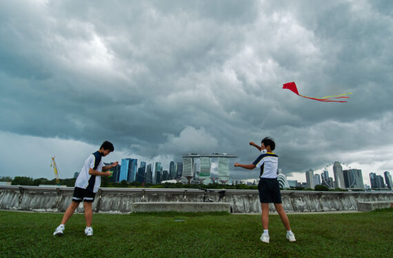 SINGAPURA, Dua orang anak menerbangkan layang-layang di sebuah rooftop garden di Marina Barrage, Singapura, pada 21 Juni 2022. (Xinhua/Then Chih Wey)