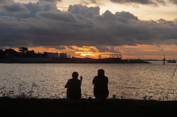 SINGAPURA, Dua sejoli menikmati pemandangan matahari terbenam di Marina Barrage Field, Singapura, pada 21 Juni 2022. (Xinhua/Then Chih Wey)