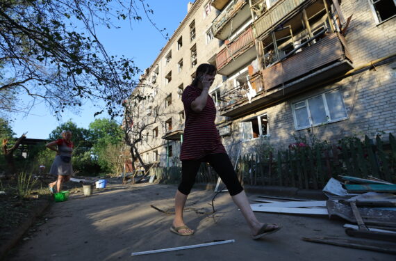 DONETSK, Sejumlah orang berjalan melewati sebuah bangunan yang rusak di Donetsk pada 20 Juni 2022. (Xinhua/Victor)
