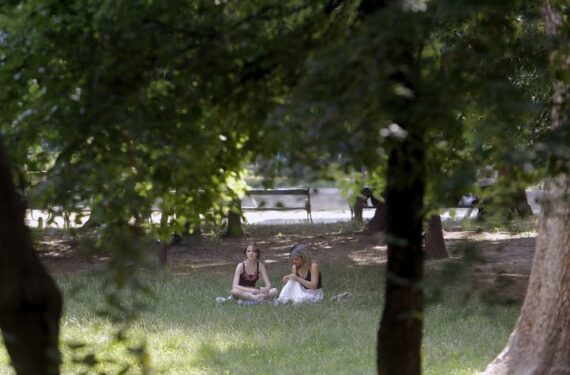 BUCHAREST, Sejumlah orang duduk di tempat yang teduh saat gelombang panas melanda di sebuah taman di pusat kota Bucharest, Rumania, pada 21 Juni 2022. (Xinhua/Cristian Cristel)
