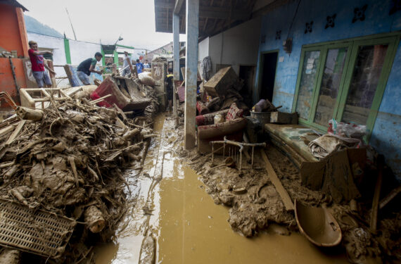 BOGOR, Warga membersihkan lumpur di sekitar rumah mereka yang rusak usai banjir yang dipicu oleh hujan lebat menerjang wilayah Cisarua di Kabupaten Bogor, Provinsi Jawa Barat, pada 23 Juni 2022. (Xinhua/Sandika Fadilah)