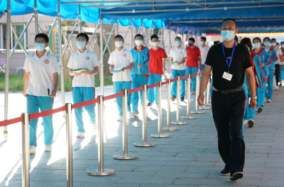 BEIJING, Seorang staf memandu para siswa untuk memasuki lokasi ujian masuk sekolah menengah atas (SMA) 2022 di Distrik Pinggu, Beijing, ibu kota China, pada 24 Juni 2022. Ujian masuk SMA 2022 di Beijing dimulai pada Jumat (24/6). (Xinhua/Ren Chao)