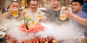 QIANJIANG, Sejumlah orang mencicipi lobster di sebuah restoran di Qianjiang, Provinsi Hubei, China tengah, pada 24 Juni 2022. Industri terkait lobster di Qianjiang membentuk rantai industri yang lengkap, termasuk pembiakan, pemrosesan dan ekspor, katering, dan perdagangan elektronik (e-commerce). (Xinhua/Wu Zhizun)