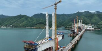 HEFEI, Foto dari udara yang diabadikan pada 29 Juni 2022 ini menunjukkan menara utama jembatan besar Danau Taiping di Huangshan, Provinsi Anhui, China timur. Struktur penutup (cap) menara utama ketiga di jembatan besar Danau Taiping telah dipasang pada Rabu (29/6), menandai rampungnya pembangunan tiga menara utama di jembatan itu. Jembatan besar Danau Taiping merupakan proyek krusial di Jalur Kereta Chizhou-Huangshan dengan total panjang mencapai 926,1 meter. (Xinhua/Weng Xiaohu)