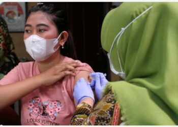 SURAKARTA - Tenaga kesehatan menyuntikkan dosis penguat (booster) vaksin COVID-19 kepada seorang pria di Surakarta, Provinsi Jawa Tengah, pada 7 Juni 2022. (Xinhua/Bram Selo)
