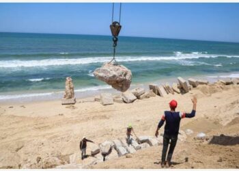 GAZA CITY - Sejumlah insinyur dan pekerja Palestina menggunakan derek untuk menempatkan balok-balok beton guna mencegah erosi pantai di Gaza City pada 9 Juni 2022. (Xinhua/Rizek Abdeljawad)