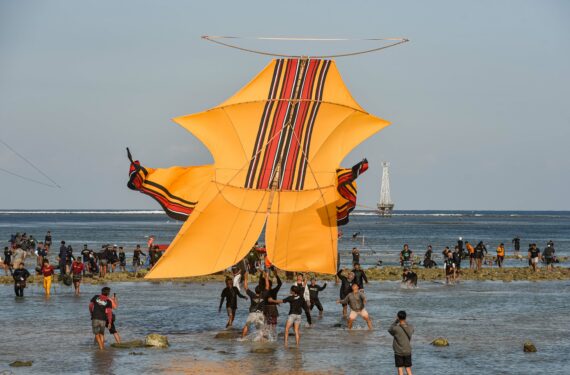 BALI, Sejumlah orang menerbangkan layang-layang berukuran besar saat festival layang-layang yang diadakan di Pantai Mertasari di Sanur, Provinsi Bali, pada 31 Juli 2022. Festival layang-layang tradisional ini menarik ribuan pengunjung dengan pemandangan aneka layang-layang yang menawan. (Xinhua/Bisinglasi)