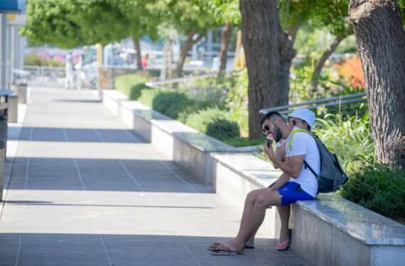 LIMASSOL, Seorang pria menikmati es krim di tempat teduh di Limassol, Siprus, pada 4 Agustus 2022. Departemen Meteorologi Siprus pada Kamis (4/8) mengeluarkan peringatan kuning baru untuk suhu tinggi. (Xinhua/George Christophorou)