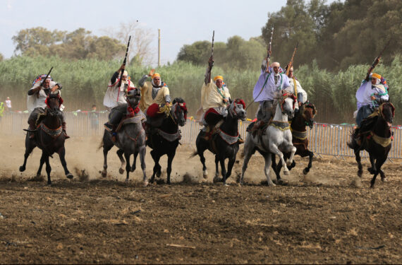 ALJIR, Mengenakan pakaian tradisional, sejumlah penampil menunggang kuda dalam pertunjukan berkuda Fantasia di Aljir, Aljazair, pada 5 Agustus 2022. Fantasia adalah pertunjukan tradisional keterampilan berkuda yang dilakukan selama gelaran budaya di kawasan Afrika utara. (Xinhua)