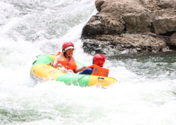 KAIYANG, Sejumlah wisatawan mengarungi sebuah sungai menggunakan perahu karet di objek wisata ngarai besar Nanjiang di wilayah Kaiyang, Provinsi Guizhou, China barat daya, pada 10 Agustus 2022. Objek wisata tersebut menjadi tujuan favorit bagi para wisatawan untuk menghindari teriknya musim panas. (Xinhua/Zheng Minghong)