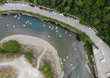 KAIYANG, Foto dari udara yang diabadikan pada 10 Agustus 2022 ini menunjukkan para wisatawan mengarungi sebuah sungai menggunakan perahu karet di objek wisata ngarai besar Nanjiang di wilayah Kaiyang, Provinsi Guizhou, China barat daya. Objek wisata tersebut menjadi tujuan favorit bagi para wisatawan untuk menghindari teriknya musim panas. (Xinhua/Xiang Dingjie)