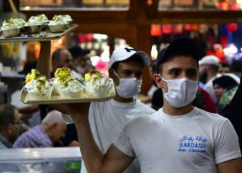 DAMASKUS, Seorang pria Suriah menghidangkan es krim Arab di sebuah toko di Damaskus, Suriah, pada 8 Agustus 2022. (Xinhua/Ammar Safarjalani)
