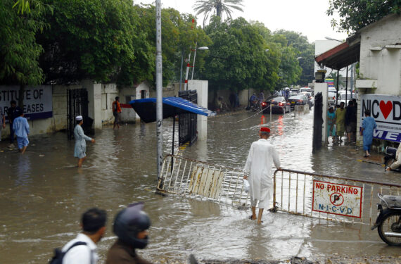 KARACHI, Orang-orang menerjang banjir setelah hujan deras mengguyur kota pelabuhan Karachi di Pakistan selatan pada 12 September 2022. (Xinhua/Str)