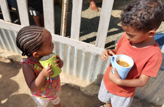WINDHOEK, Anak-anak memegang cangkir berisi makanan di Needy Hearts Soup Kitchen di Hakahana, sebuah permukiman kumuh di Windhoek, Namibia, pada 12 September 2022. (Xinhua/Ndalimpinga Iita)